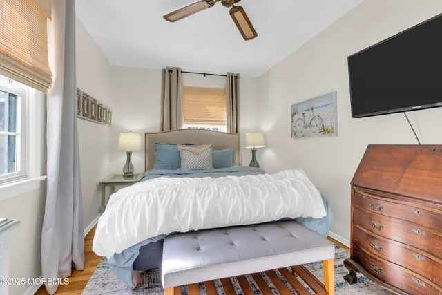 a bedroom with a bed a flat screen tv and a window