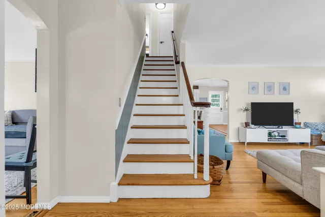 a view of a livingroom with stairs and an empty room