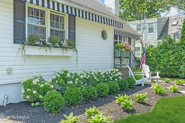 a front view of a house with a yard and potted plants