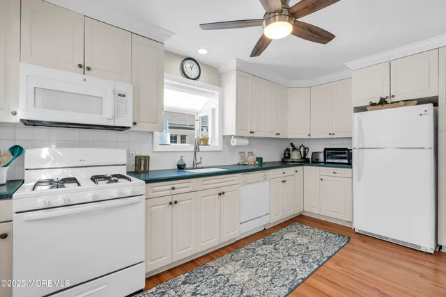 a kitchen with white cabinets and white appliances