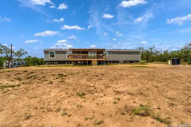 a view of a yard with plants and trees