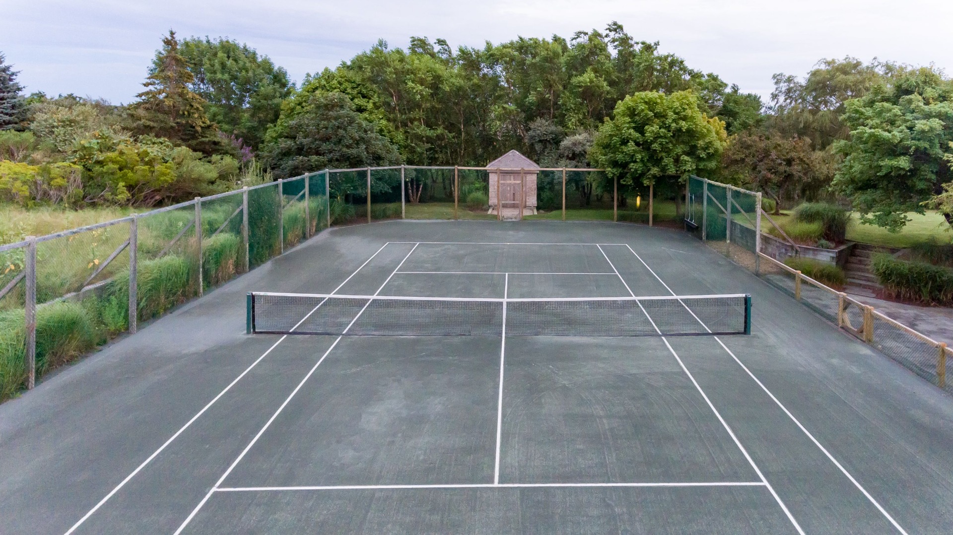 183 Polpis Road Nantucket, MA 02554 - Photo 60 of 62 a view of a tennis court with lots of trees in the background