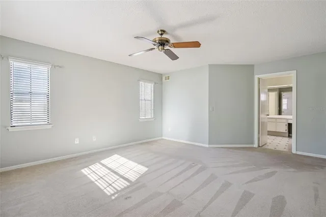 a view of empty room with window and ceiling fan