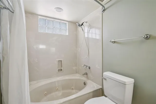 a white bath tub sitting next to a toilet
