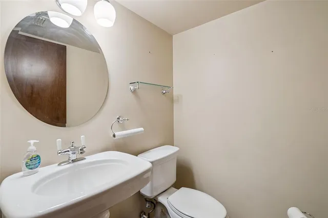 a bathroom with a sink mirror and toilet