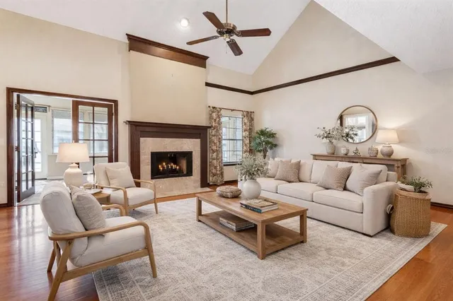 a living room with furniture a fireplace and a ceiling fan