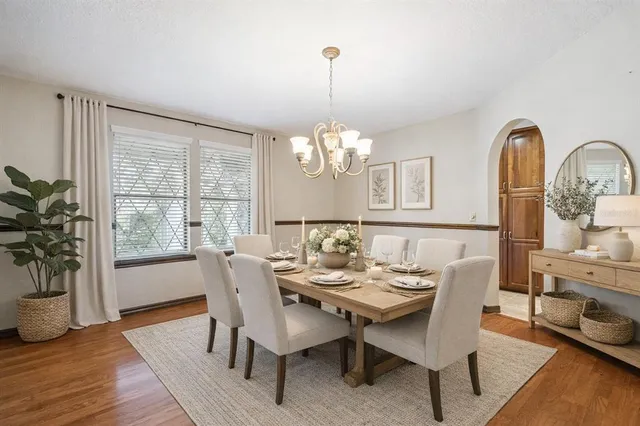 a dining room with furniture a chandelier and wooden floor