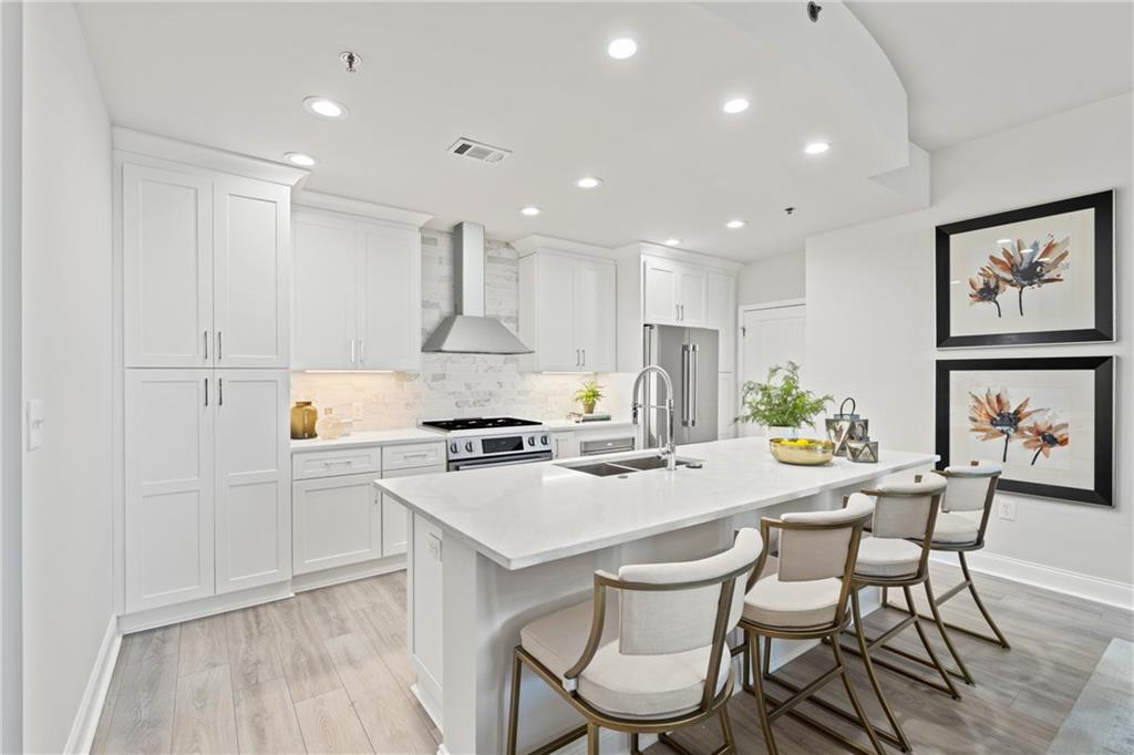 a kitchen with stainless steel appliances a white table and chairs in it