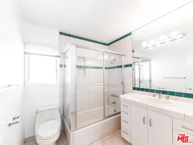 a bathroom with a granite countertop sink toilet a mirror and shower