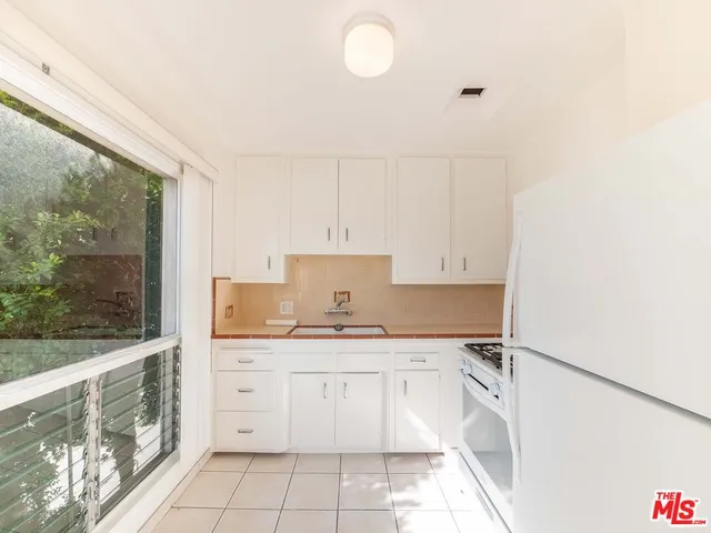 a kitchen with a sink window and cabinets