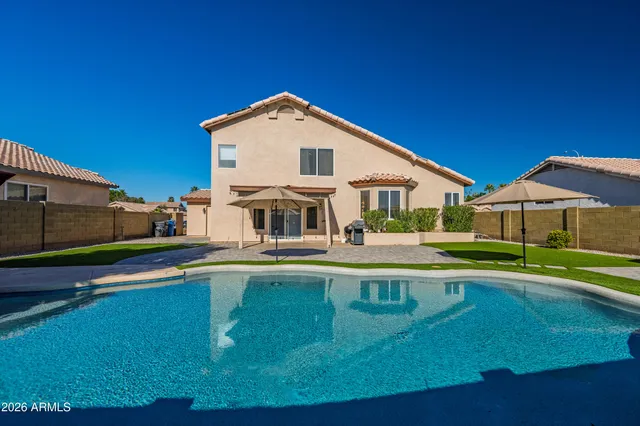 a view of a house with pool and chairs