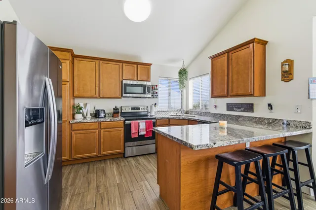 a kitchen with stainless steel appliances granite countertop a sink refrigerator and microwave
