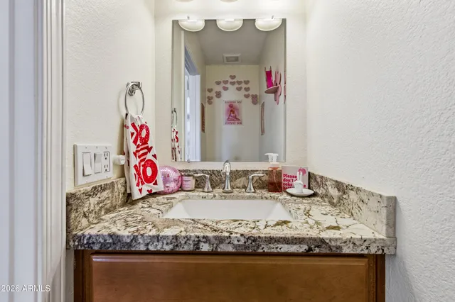 a bathroom with a granite countertop sink and a mirror
