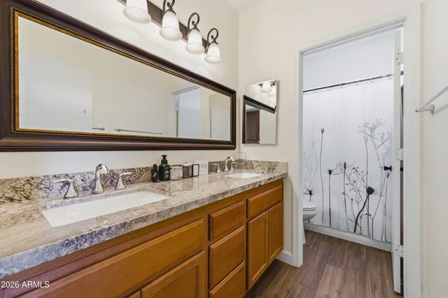 a bathroom with a granite countertop sink a mirror and shower