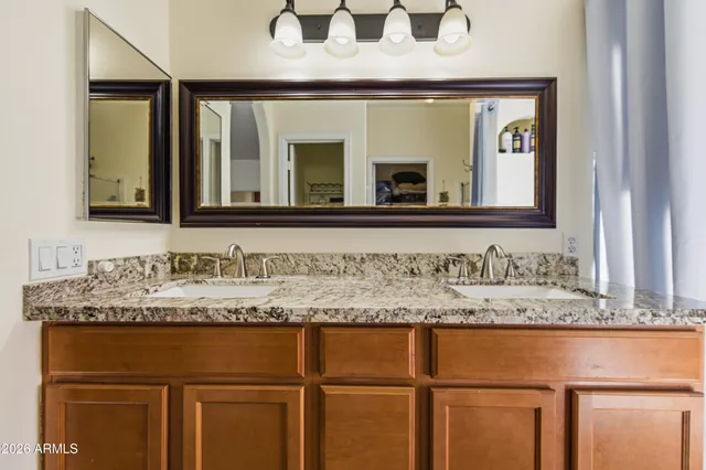 a bathroom with a granite countertop sink and a mirror
