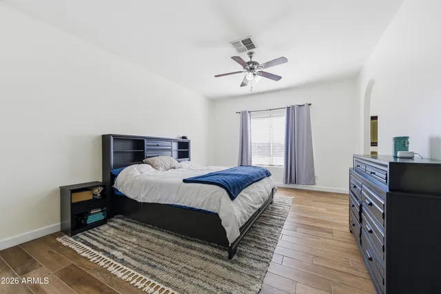 a bedroom with a bed and wooden floor