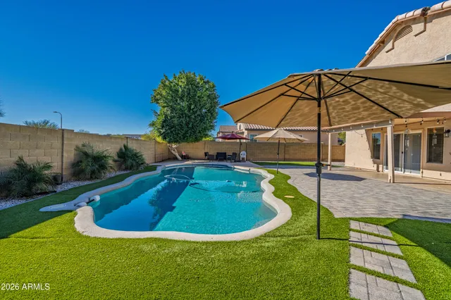 a view of a swimming pool with a yard and sitting space
