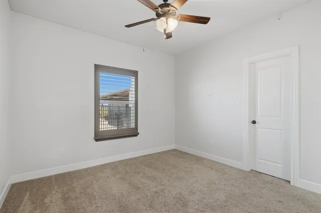 an empty room with a window and a fan