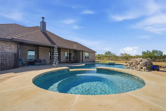 a view of a house with swimming pool and sitting area