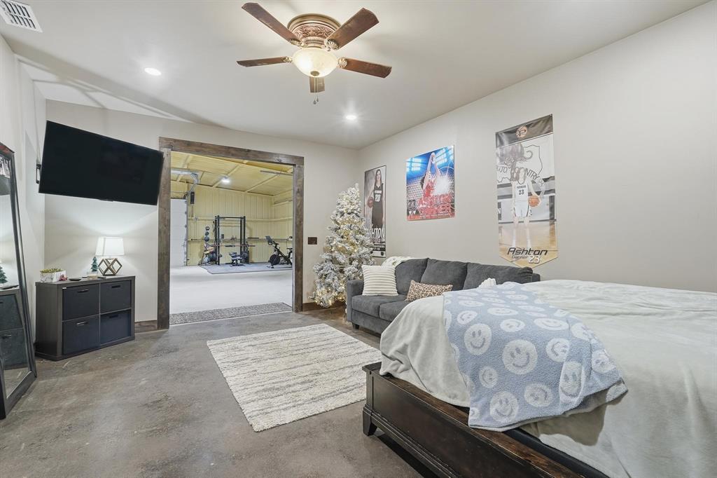 163 Homestead Road Tuscola, TX 79562 - Photo 34 of 40 a spacious bedroom with a bed and a chandelier