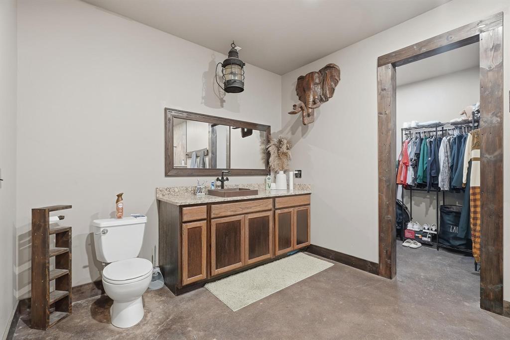 163 Homestead Road Tuscola, TX 79562 - Photo 36 of 40 a bathroom with a toilet sink and mirror