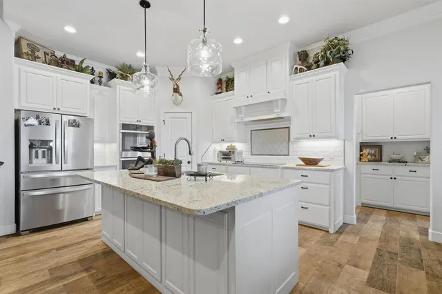 a kitchen with cabinets a sink and stainless steel appliances
