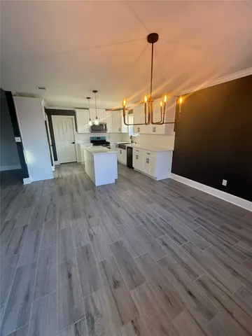 a view of a kitchen with furniture and wooden floor