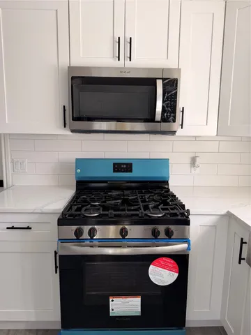 a stove top oven sitting inside of a kitchen