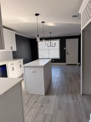 a view of a kitchen with a fridge and wooden floor