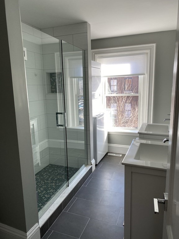 1 Wigglesworth Street, Unit 2 Boston, MA 02120 - Photo 15 of 23 a bathroom with a shower sink and mirror