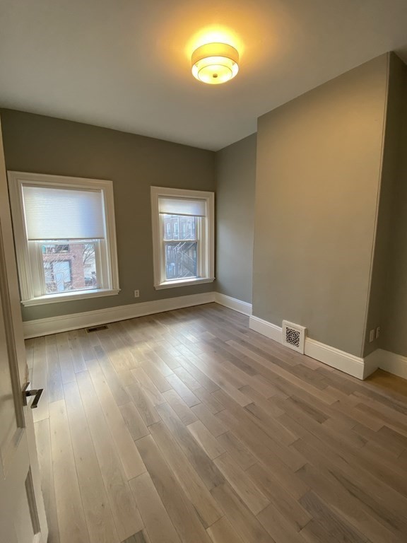 1 Wigglesworth Street, Unit 2 Boston, MA 02120 - Photo 18 of 23 an empty room with wooden floor and windows