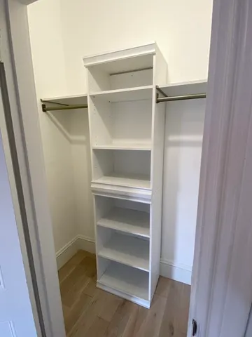 a view of walk in closet with empty racks