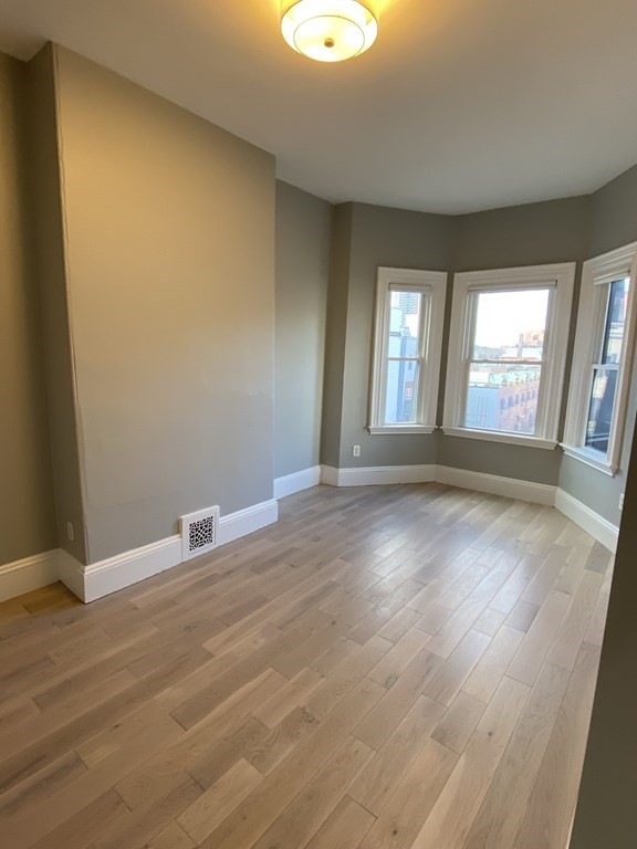 1 Wigglesworth Street, Unit 2 Boston, MA 02120 - Photo 20 of 23 an empty room with wooden floor and windows