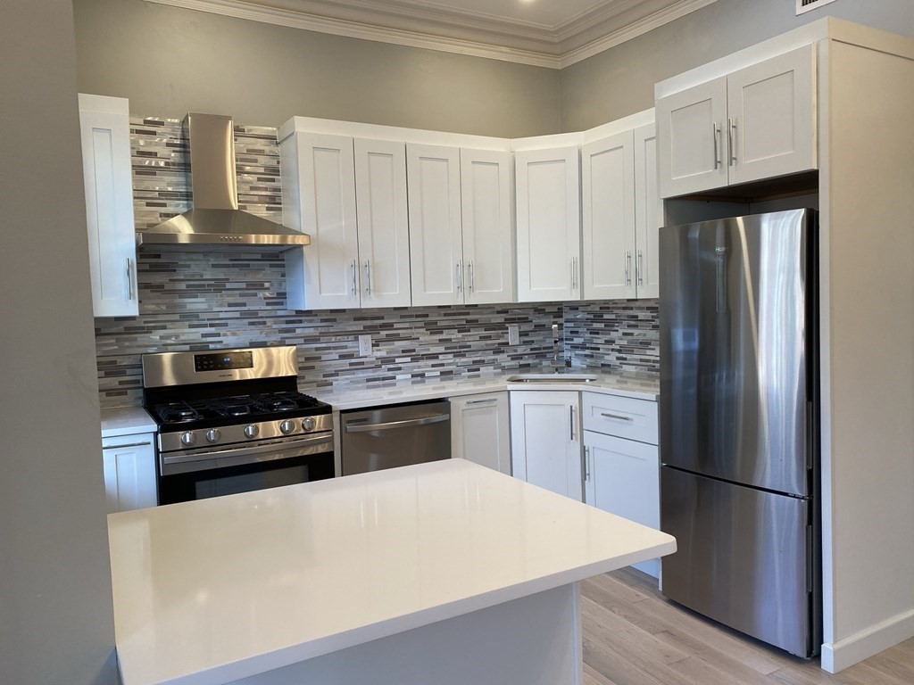 1 Wigglesworth Street, Unit 2 Boston, MA 02120 - Photo 2 of 23 a kitchen with a refrigerator and a stove top oven