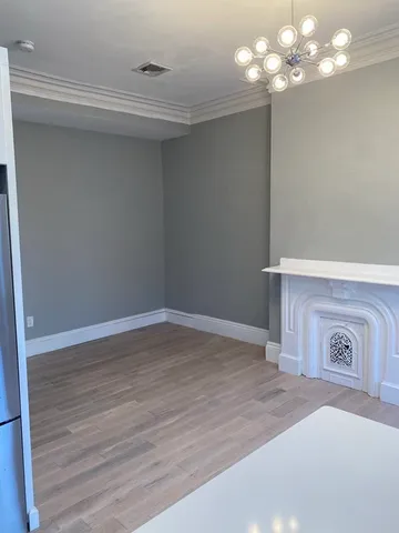 a view of a room with wooden floor and chandelier