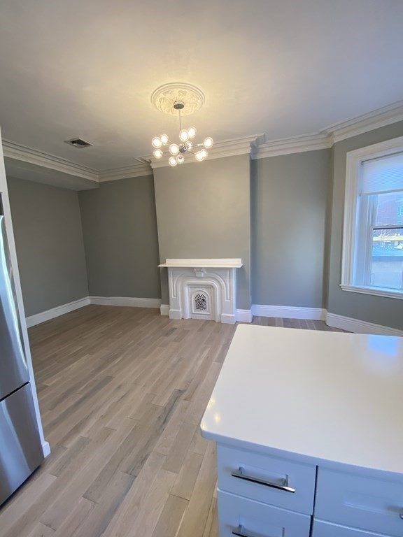 1 Wigglesworth Street, Unit 2 Boston, MA 02120 - Photo 6 of 23 a view of a room with wooden floor and chandelier