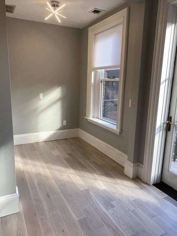 1 Wigglesworth Street, Unit 2 Boston, MA 02120 - Photo 9 of 23 an empty room with wooden floor and windows