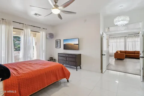 a bedroom with a bed and a television on the dresser