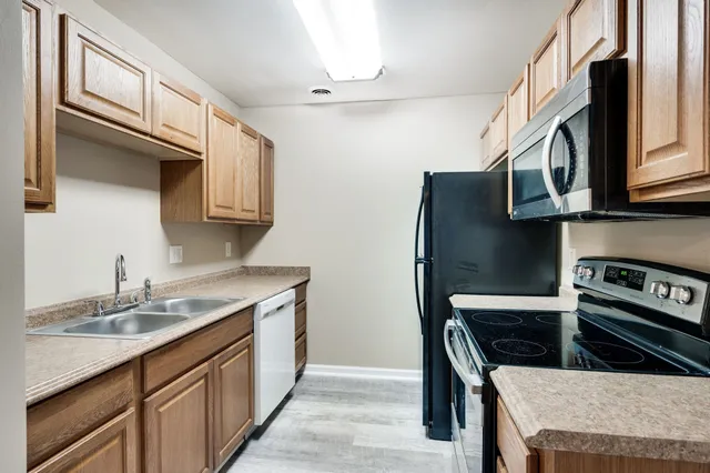 a kitchen with stainless steel appliances granite countertop a sink stove and refrigerator