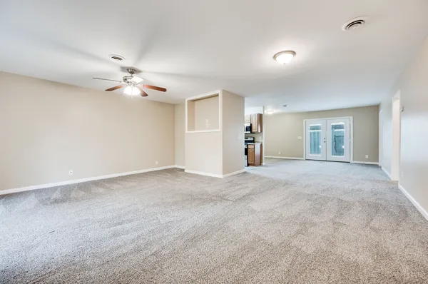 a view of an empty room with a ceiling fan