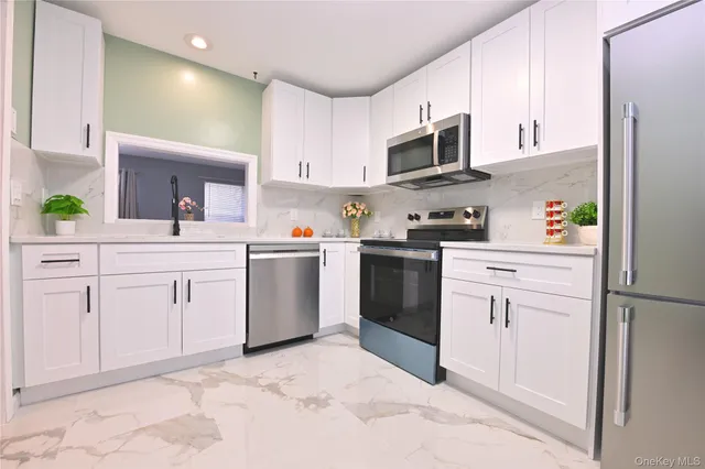 a kitchen with white cabinets stainless steel appliances and sink
