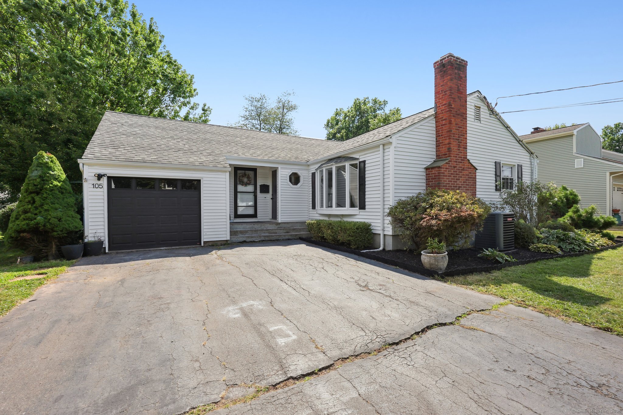 a front view of a house with a yard and potted plants