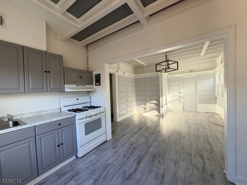 324 Summer Avenue, Unit 3 Newark, NJ 07104 - Photo 4 of 12 a kitchen with a hard wood floor white cabinets and stainless steel appliances