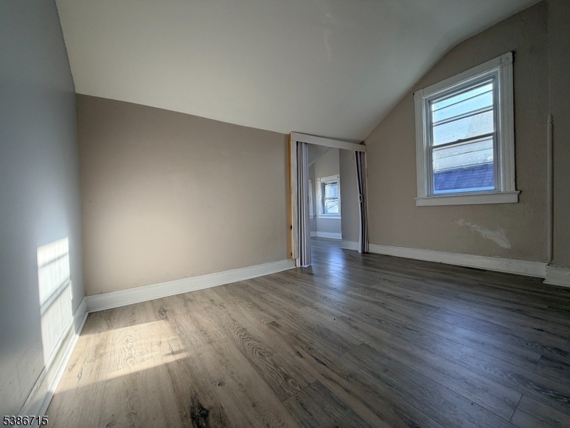 324 Summer Avenue, Unit 3 Newark, NJ 07104 - Photo 7 of 12 an empty room with wooden floor and windows