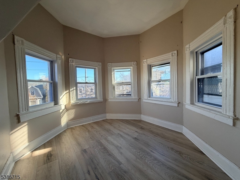 324 Summer Avenue, Unit 3 Newark, NJ 07104 - Photo 8 of 12 a view of an empty room with wooden floor and a window