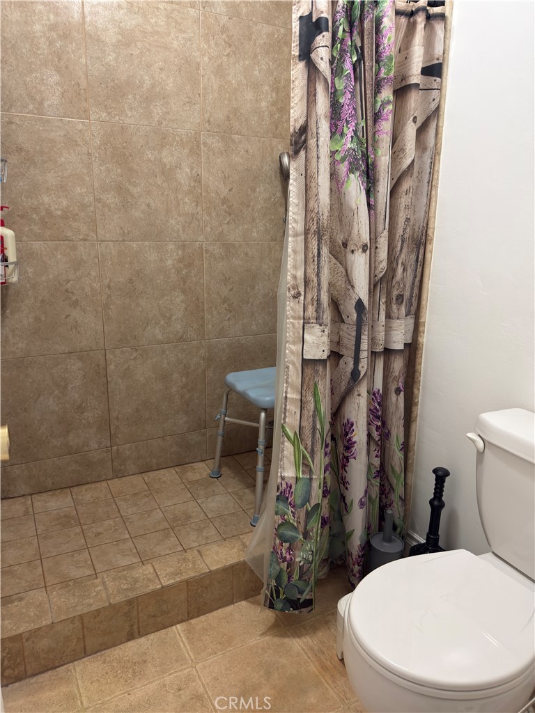 1340 West Lambert Road, Unit 85 La Habra, CA 90631 - Photo 12 of 17 a white toilet sitting next to a shower curtain
