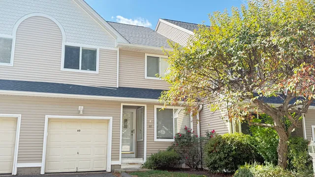 a front view of a house with a tree
