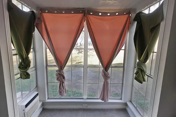 a view of walk in closet with large window and wooden floor