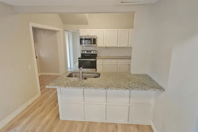 a kitchen with stainless steel appliances granite countertop a sink and a granite counter tops