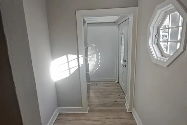 a view of empty room with wooden floor and fan